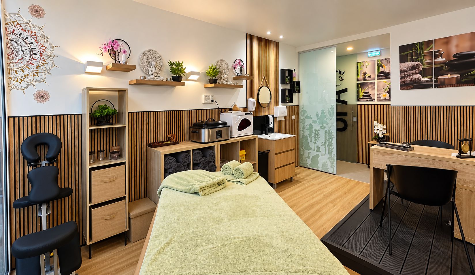 Una habitación moderna con una cama, un escritorio, una silla, un sillón de masaje y un baño pequeño.