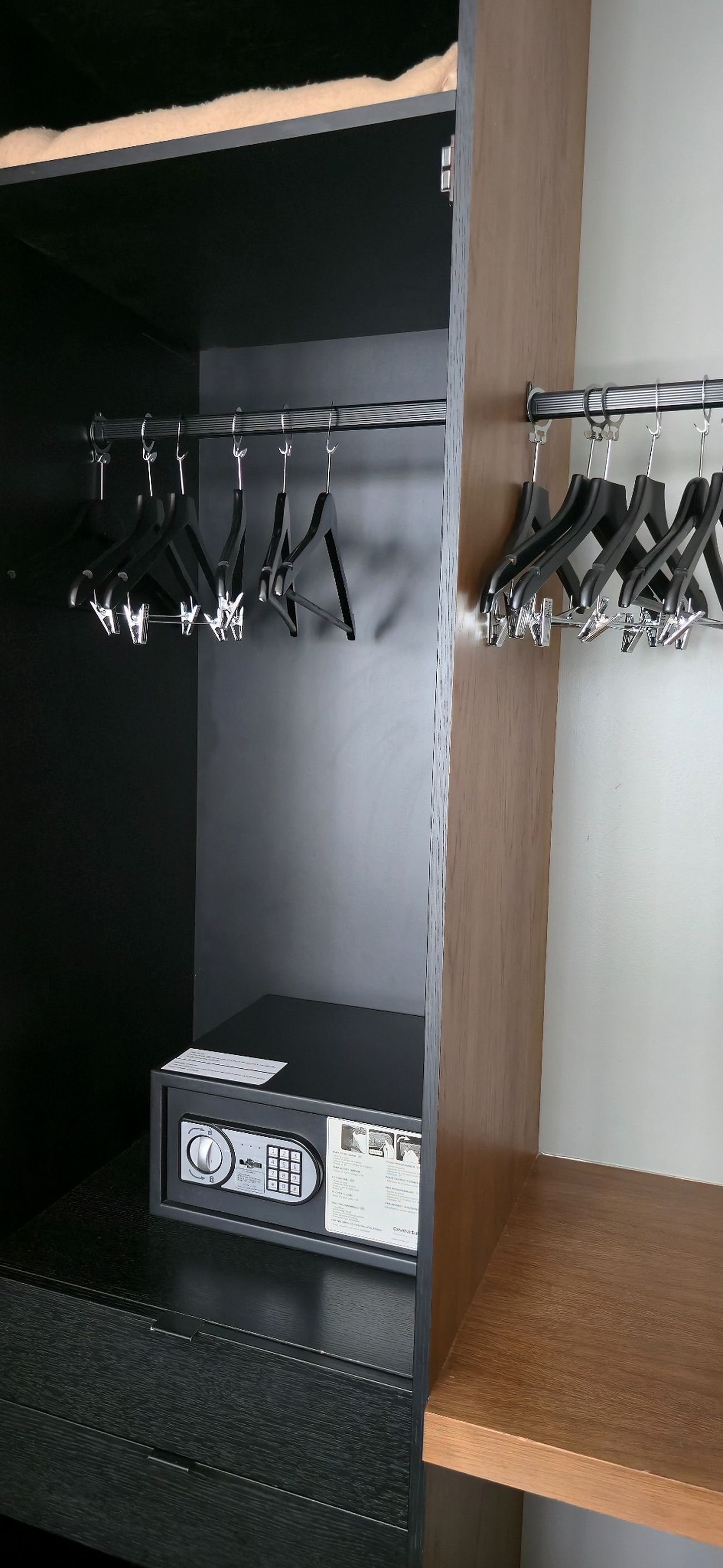 A storage area with metal hangers and a control panel.