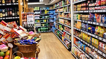 Un pasillo de supermercado con diversos productos en las estanterías y un cartel promocional.