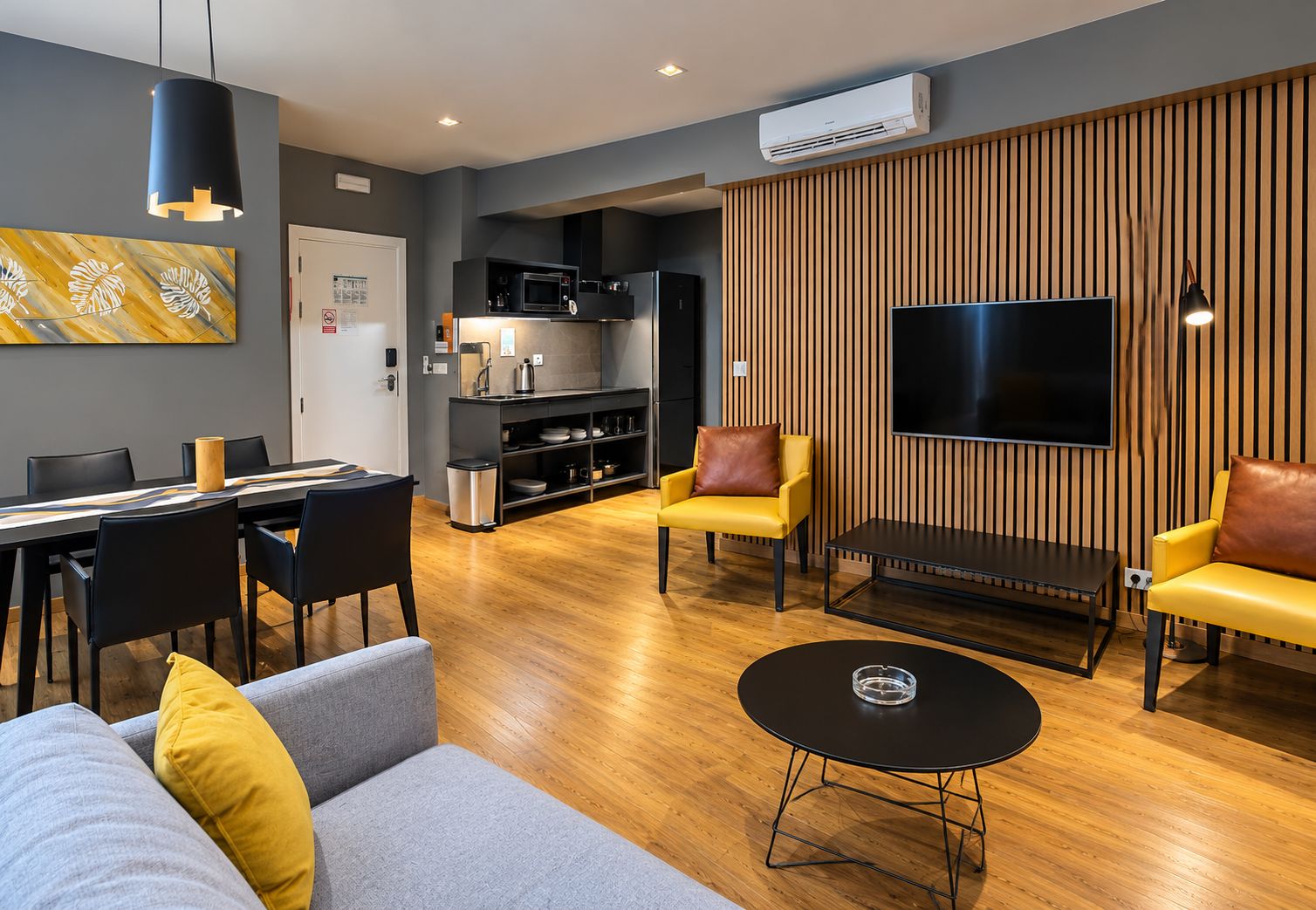 Una sala de estar moderna con un sofá, sillones, una mesa de centro y un televisor.