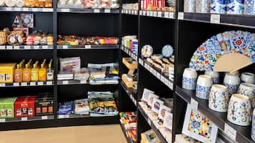 Una tienda con estantes repletos de diversos artículos, incluyendo cerámica, cristalería y objetos decorativos.
