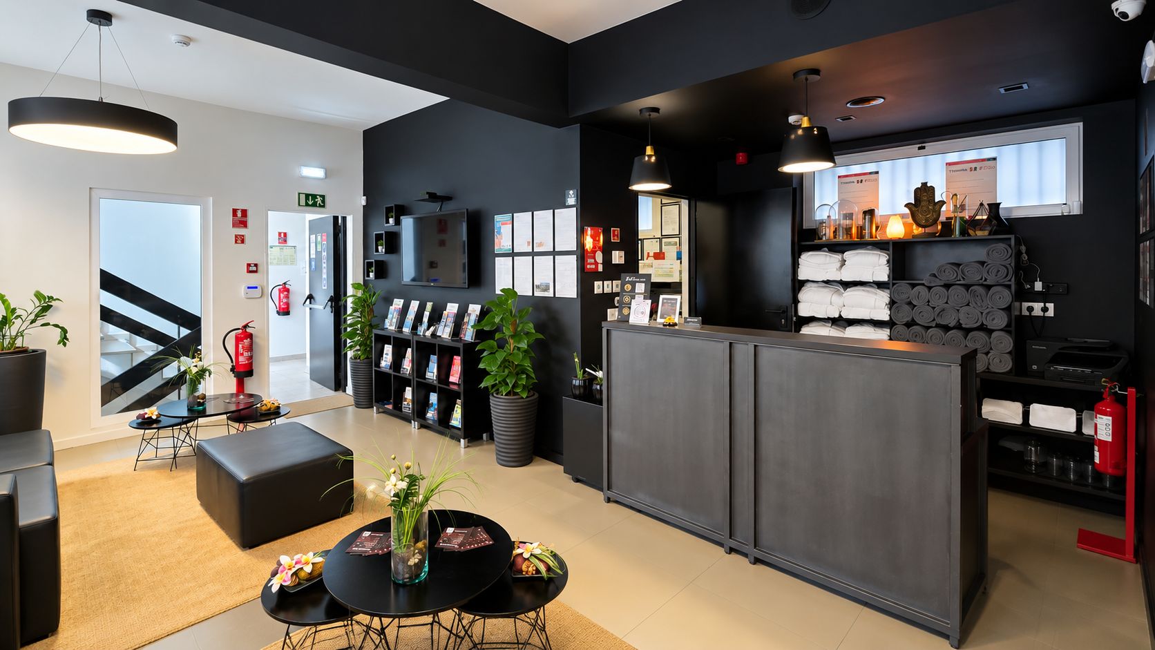 Un moderno vestíbulo de hotel con mostrador de recepción, zona de estar y una escalera.
