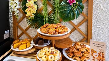 Una mesa de buffet con diversos pasteles y postres, incluyendo croissants y hojaldres, dispuestos sobre soportes de madera.