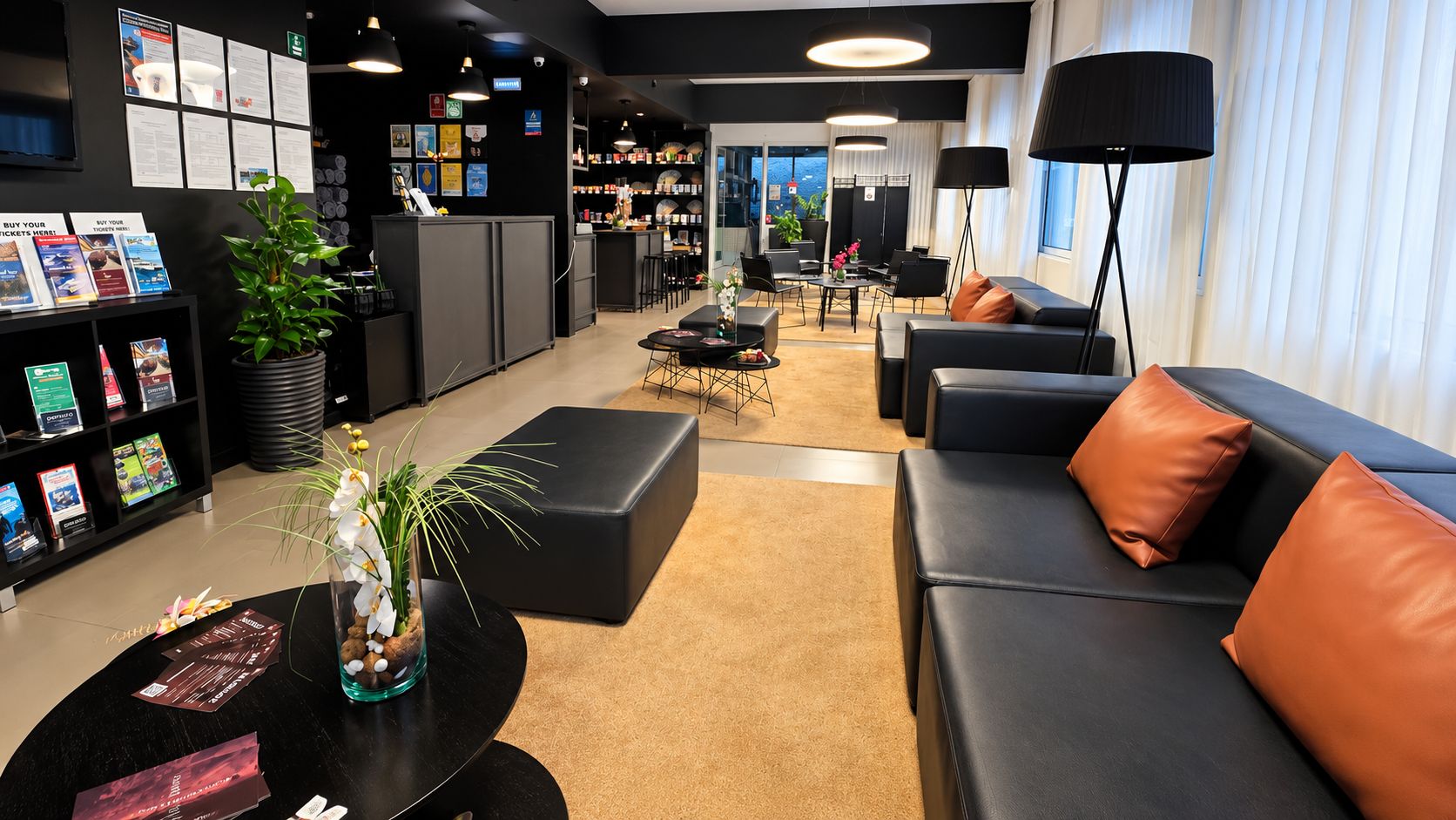 Un moderno vestíbulo de hotel con mostrador de recepción, zona de estar y vistas a la ciudad.
