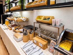 A buffet setup with various food items, utensils, and a coffee station. - Paraíso - Touristic Apartments (Funchal)
