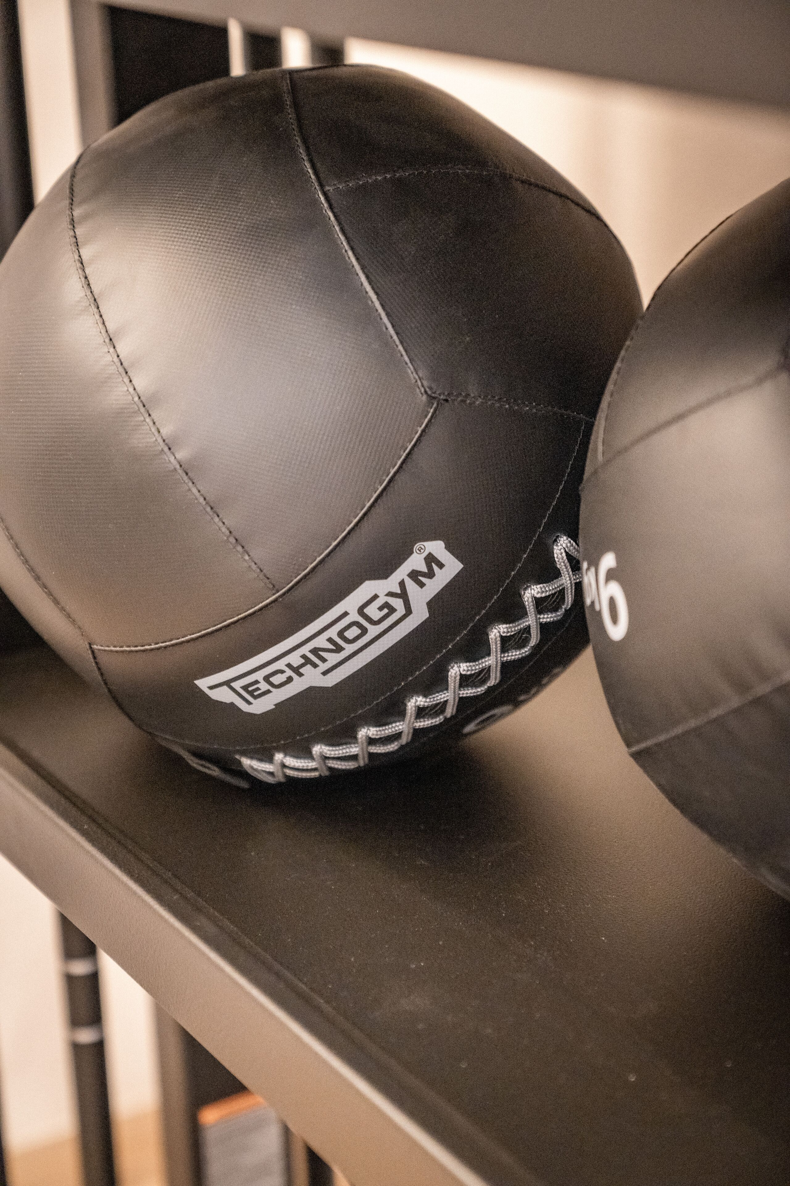 Dos pelotas deportivas negras con visible marca y un número.