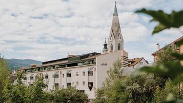 A building with a prominent tower and a sign reading "ADLER."