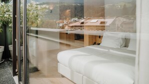 Un dormitorio con un ventanal que da a un paisaje montañoso.