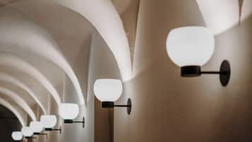 A series of wall-mounted light fixtures with a modern design, arranged in a linear pattern along a curved ceiling.