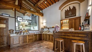 Een keuken met houten kastjes, een bar met krukken, en een stadsgezicht bord boven de bar.