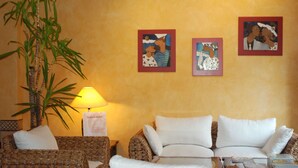 A living room with a sofa set, a lamp, and wall art. - L'Àgora Hotel (Bocairente)