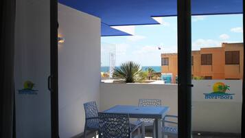 Apartamento conforto, 1 quarto, sacada, vista parcial para o mar | Escrivaninha, cortinas blackout, roupa de cama
