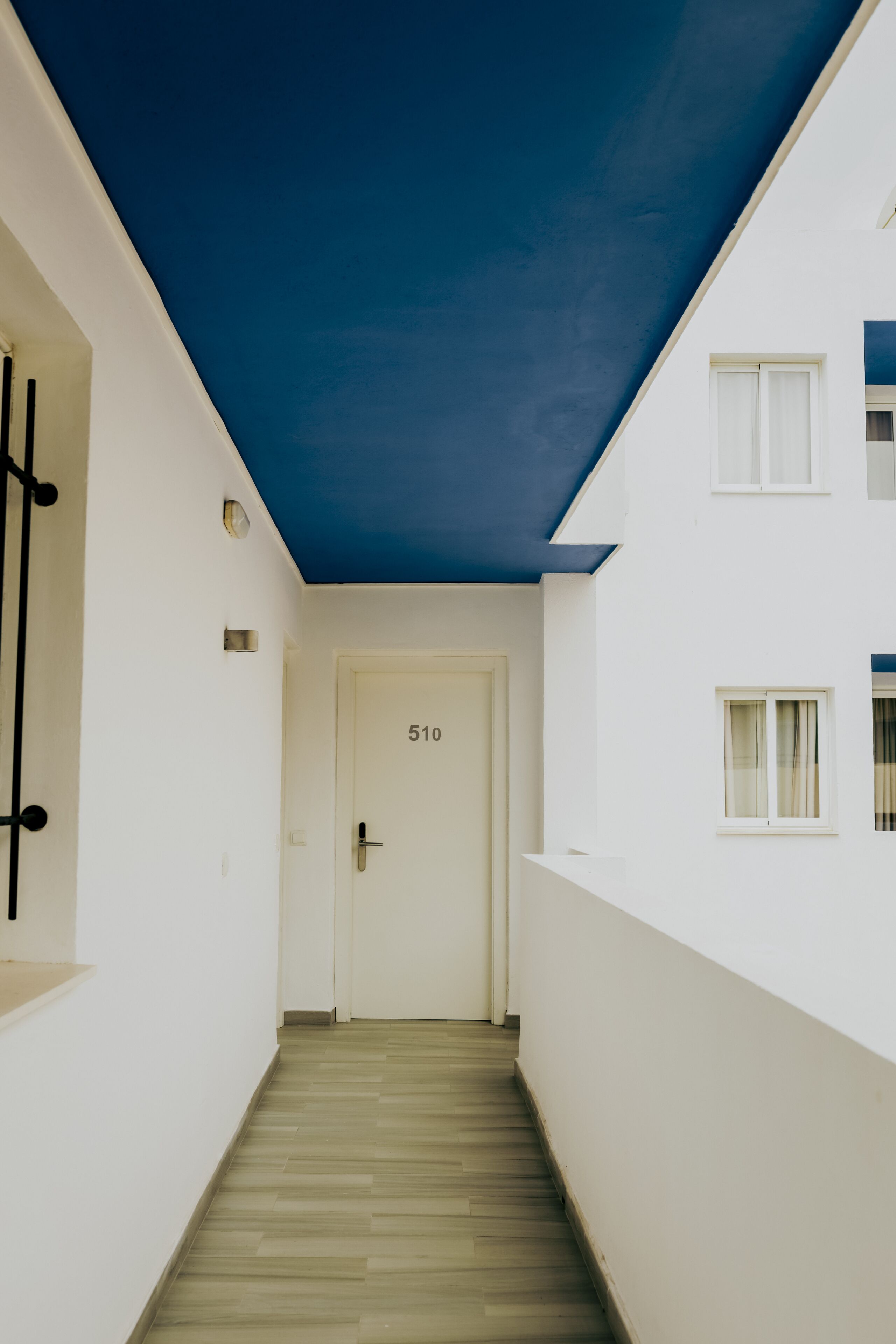 A narrow hallway with a wooden floor leading to a white door marked "510".