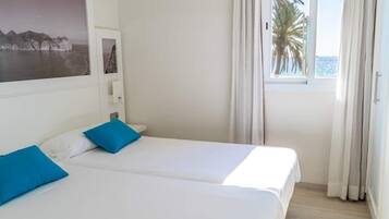 Apartamento superior, 1 habitación, vistas parciales al mar | Escritorio, cortinas opacas, ropa de cama
