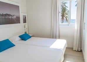 Apartamento conforto, 1 quarto, sacada, vista parcial para o mar | Escrivaninha, cortinas blackout, roupa de cama