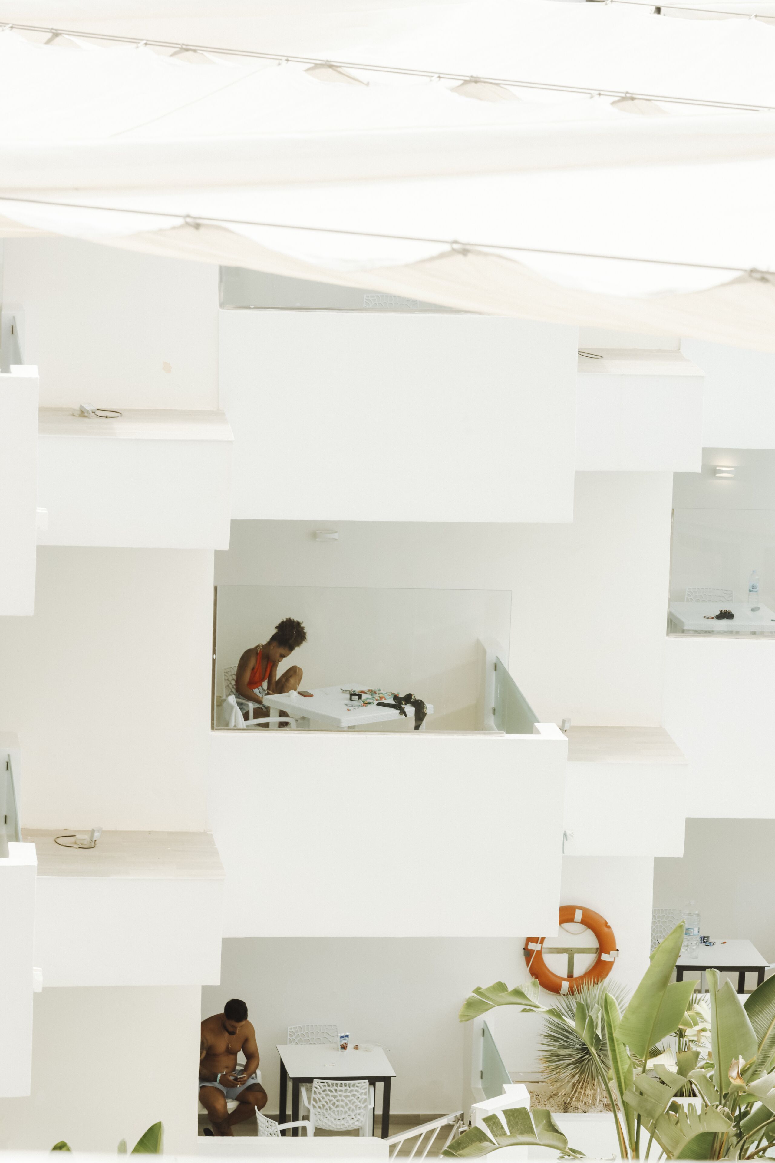A modern interior with a white color scheme, featuring a staircase, a dining area, and a seating space.