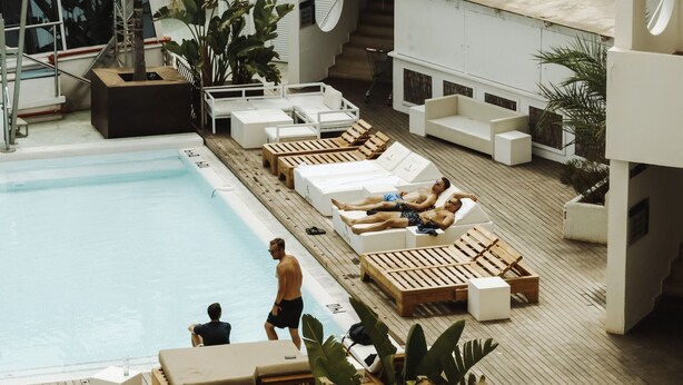 Ein Poolbereich auf dem Dach mit Liegestühlen und einem Schwimmbecken.