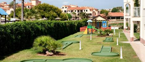 Un parcours de mini-golf avec des obstacles verts et une structure de jeu colorée.