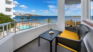 Een balkon met een zwembad, gele kussens en een plantentafel.