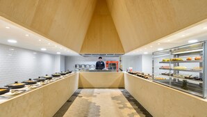 Een buffetgedeelte met een centraal bedieningspunt en meerdere eetstations aan weerszijden.