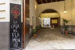 A hotel entrance with a sign for 'Hotel Alcantara' and a banner for 'La Casa del Flamenco'. - Hotel Alcántara (Seville)