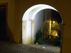 An arched doorway leading to a dimly lit street at night. - Casa João Chagas (Constancia)