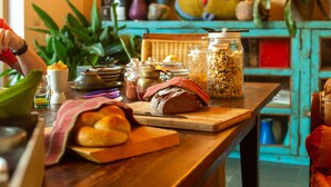 Un plan de travail de cuisine avec du pain, des bocaux et une planche à découper.