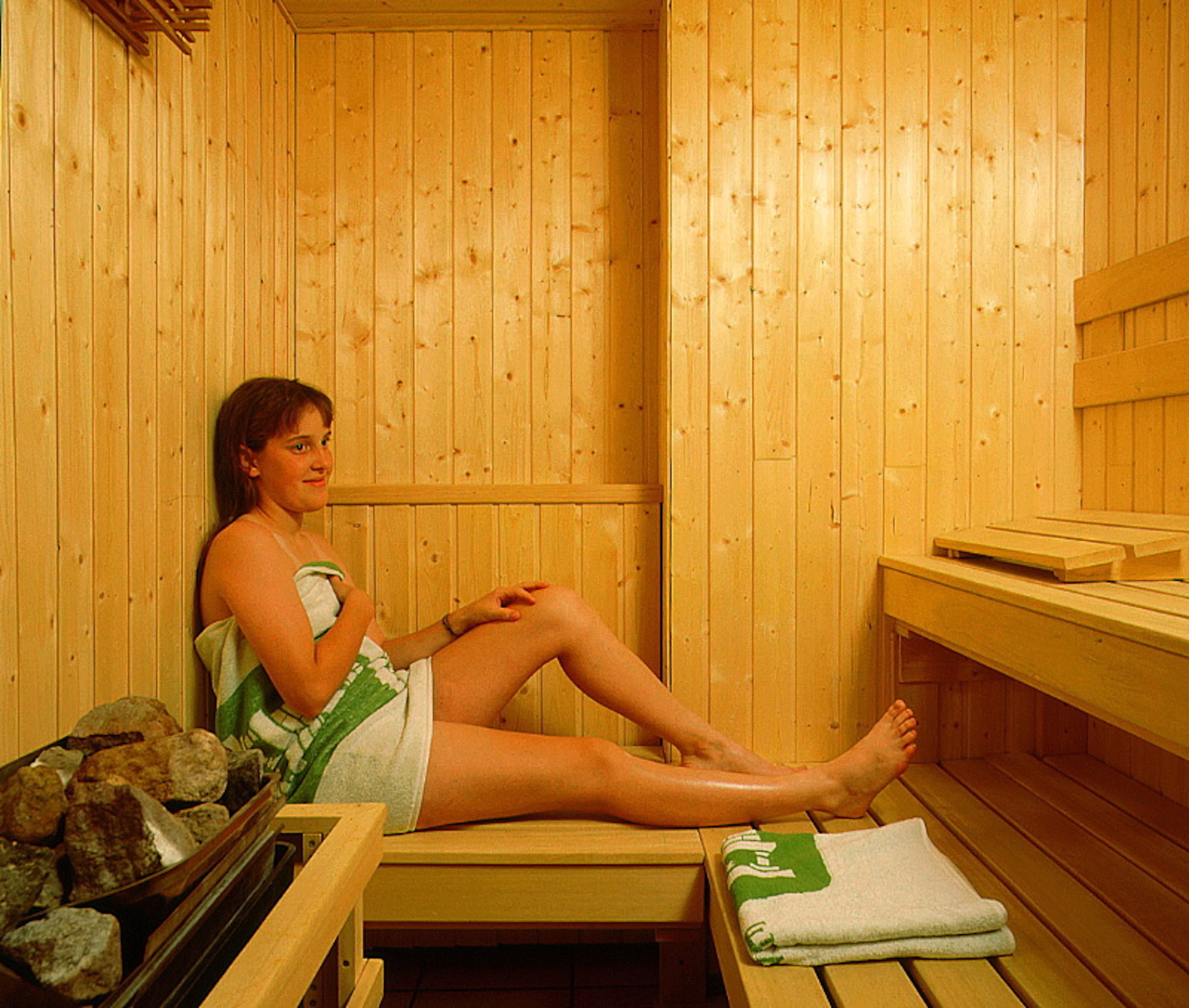A sauna room with wooden walls and benches.