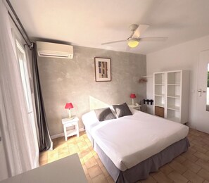 Relax in a spacious room with a large bed, bedside tables, and a ceiling fan.