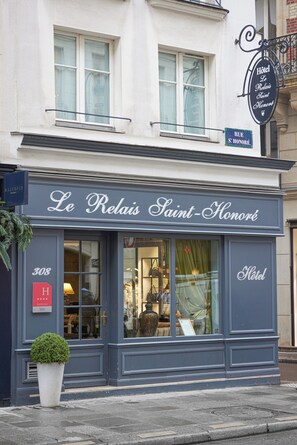 A hotel facade with a sign reading 'Le Relais Saint Honore' and a street address sign 'RUE ST. HONORE.' - Le Relais Saint Honoré (Paris)
