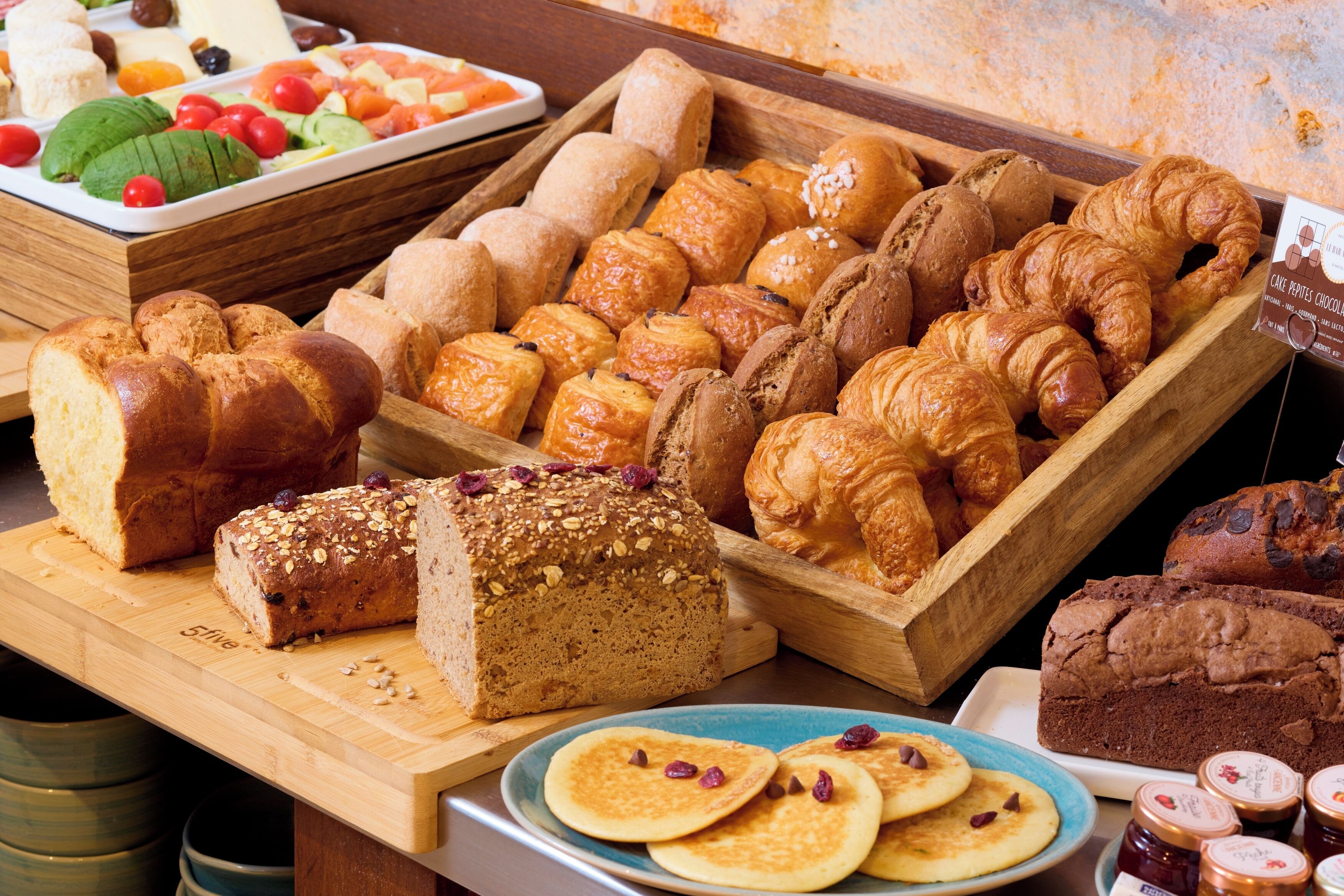 A variety of baked goods including breads, pastries, and a loaf of bread with seeds.