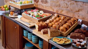 A buffet with various food items including bread, pastries, and fruits. - Le Relais Saint Honoré (Paris)