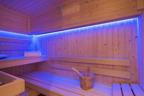 A wooden sauna with benches and a wooden bucket. - Le Relais Saint Honoré (Paris)