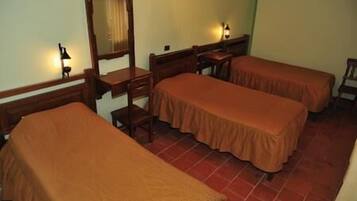 A room with two single beds, a wooden desk, a chair, and a mirror.