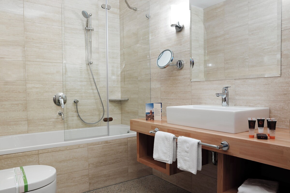 A modern bathroom with a bathtub, a sink, and a toilet.