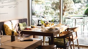 Un espace repas avec une table en bois, des chaises et une vue sur la verdure environnante.