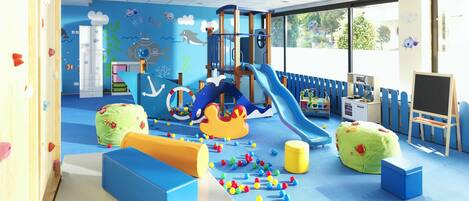 A children's play area with climbing walls, a slide, and various play structures.