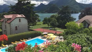A view of a mountain landscape with a lake, a swimming pool, and a small building. - Hotel Du Lac (Talloires-Montmin)