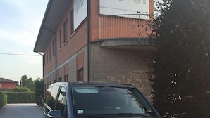 A black Mercedes-Benz van parked in front of a hotel building with a sign that reads "Hotel". - Hotel Angi (Fosso)