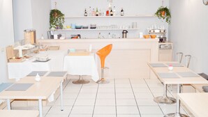 A modern kitchen with white countertops, a central island, and a bar area with stools. - Miu Hotel (Milan)
