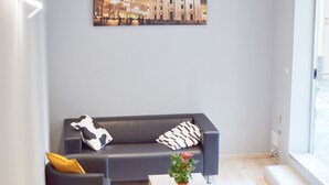 A modern living room with a grey sofa, a black armchair, and a wooden coffee table. - Miu Hotel (Milan)