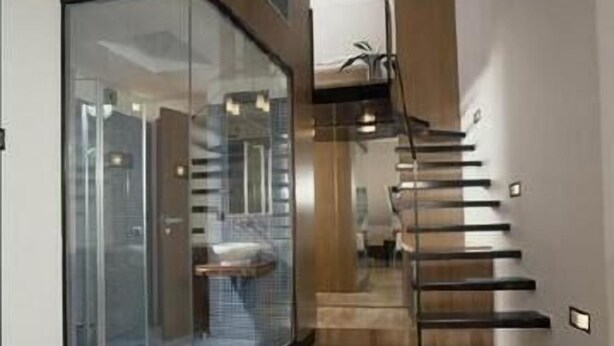A modern interior with a glass partition, a staircase, and a view into another room. - Musketyr (Prague)