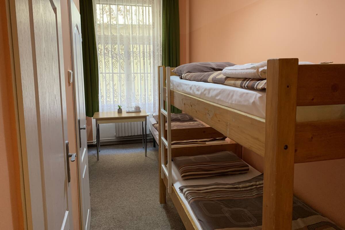 Habitación con literas, escritorio y ventana con cortinas.