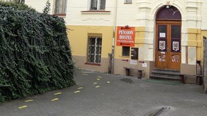 A multi-story building with a Pension Hostel sign, featuring a central entrance with a wooden door and a small porch. - Pension City Center (Prague)