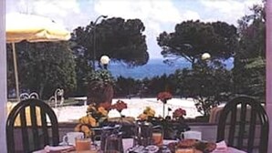 A table set for breakfast with a view of trees and a clear sky. - Mirabello (Sirmione)
