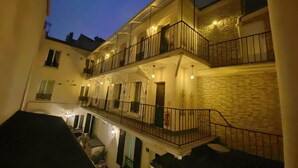 Un immeuble à plusieurs étages doté de balcons, d’escaliers et d’une cour intérieure.