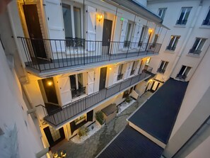 A multi-story residential building with balconies, a courtyard, and a gated entrance. - Hôtel Aviatic (Paris)