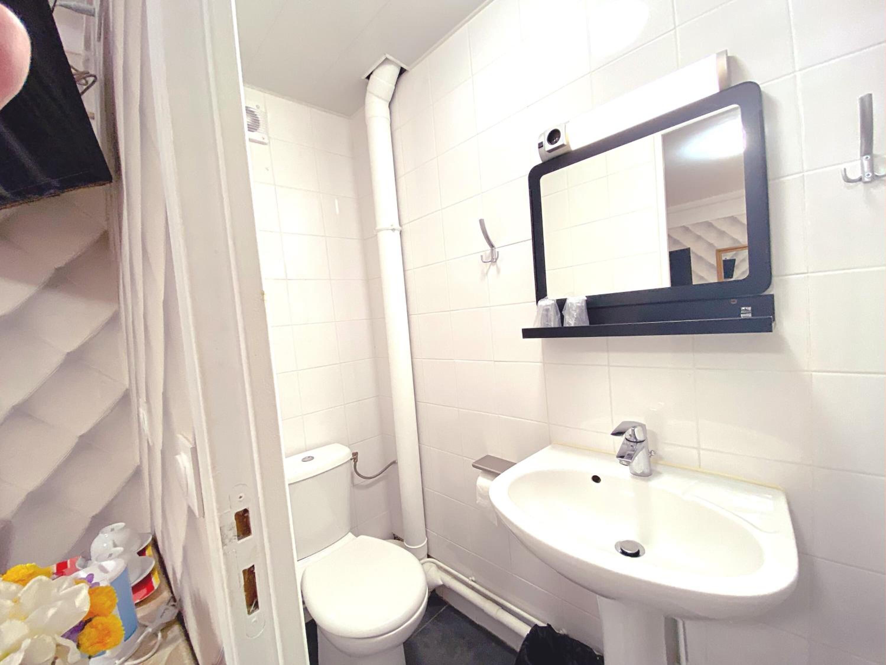 Un baño con inodoro, lavamanos, espejo y ducha.