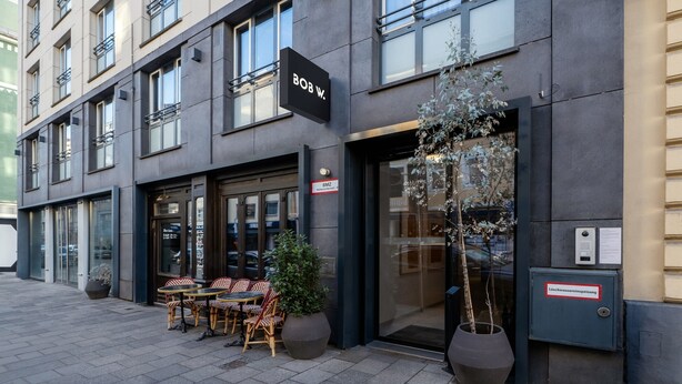 A modern building with a sign reading "BOB W." and outdoor seating with potted plants. - Bob W Münchner Freiheit (Munich)