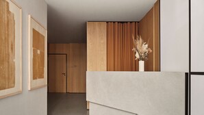 A modern interior with a wooden door, a staircase, and a vase with dried flowers. - Bob W Münchner Freiheit (Munich)